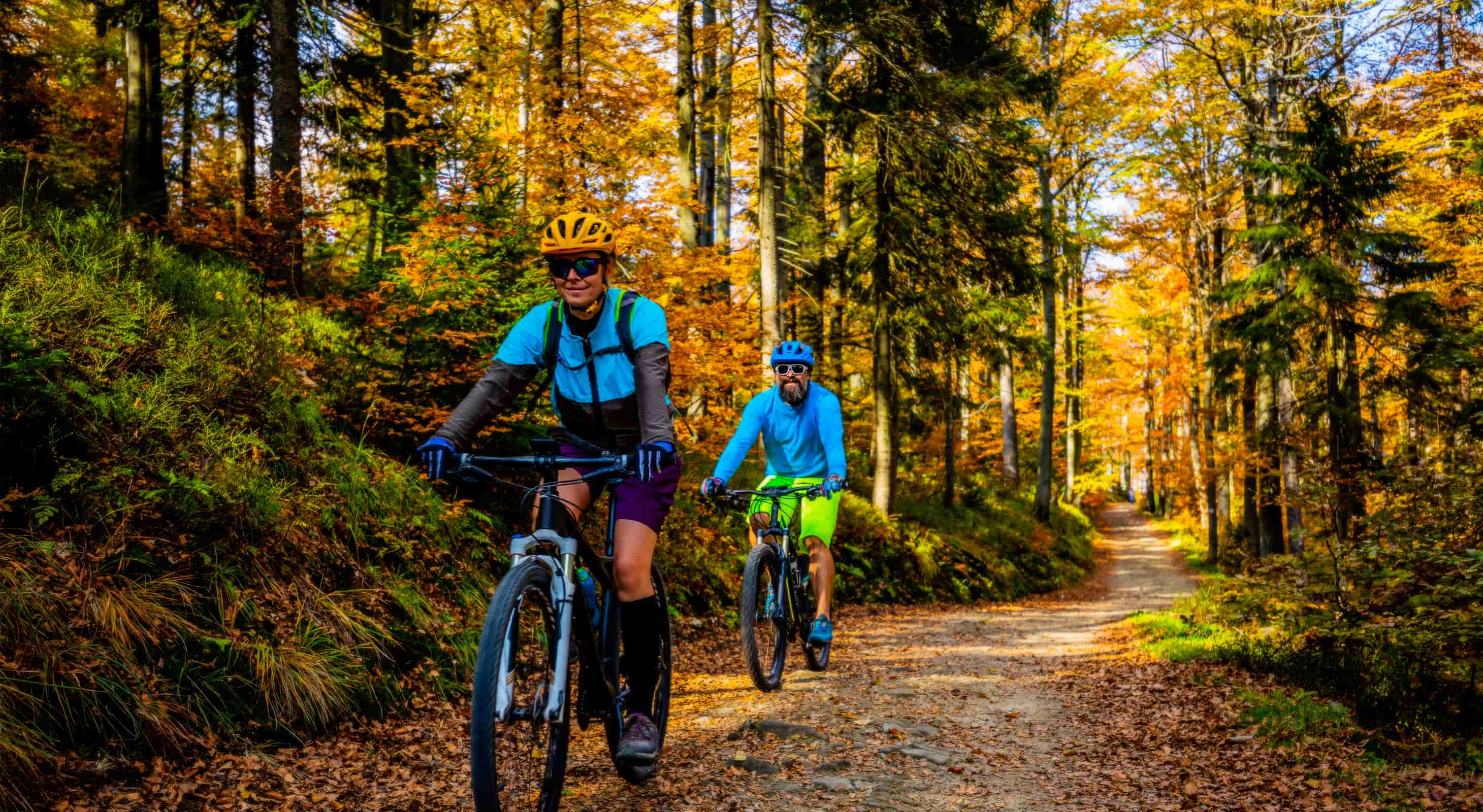 couple biking through Vermont forest