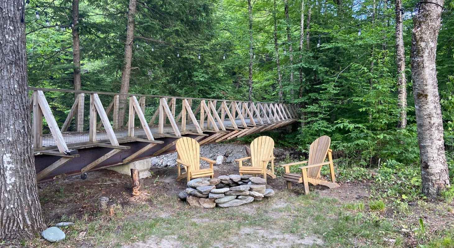 Fire pit in the backyard of Warren Lodge next to a bridge along the Mad River Path in Warren, VT
