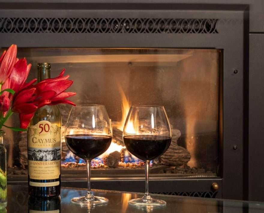 Close up of wine anf flowers in front of the fireplace in a Honeymoon Suite at Tucker Hill Lodge in Vermont