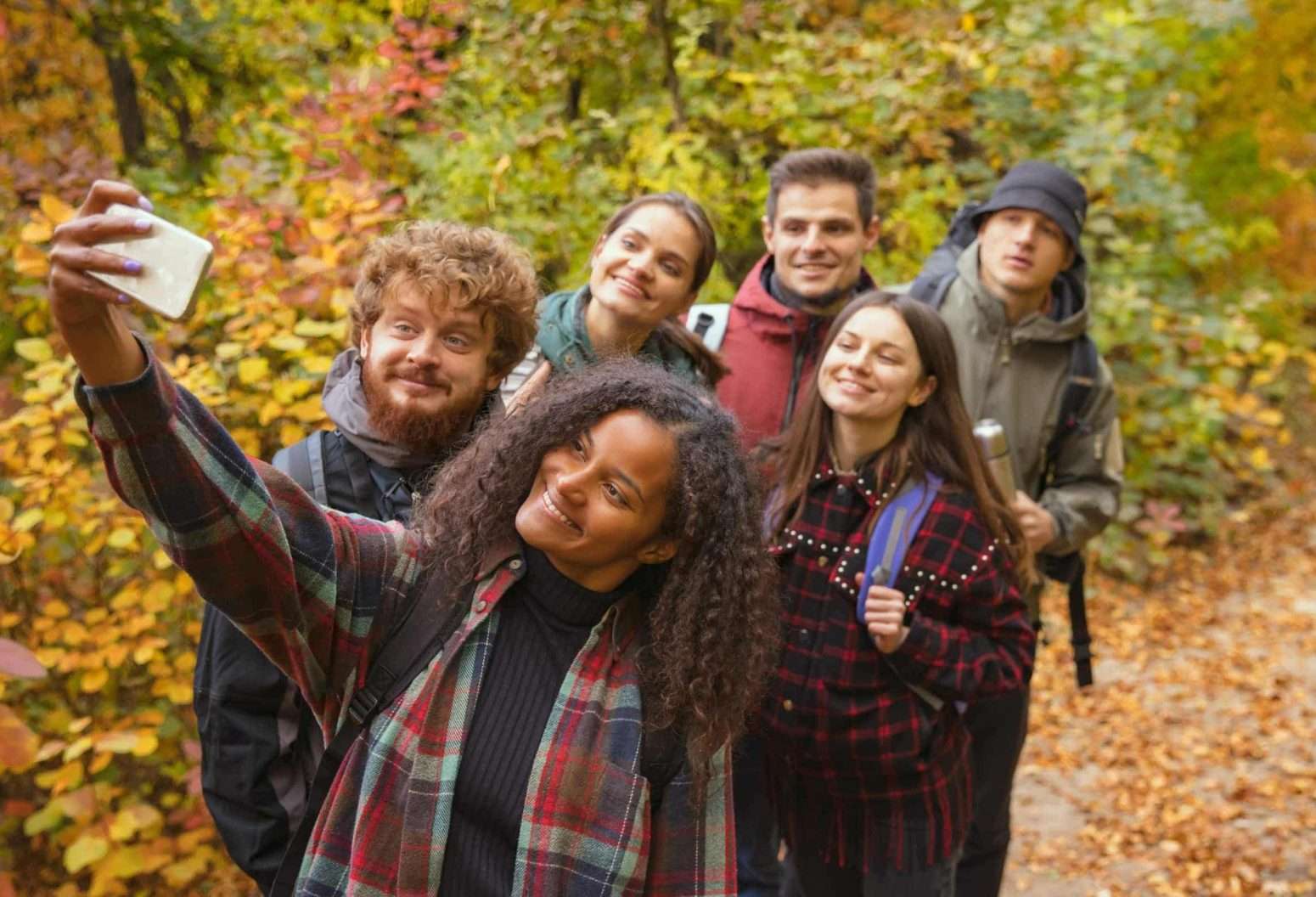 Group of young adults taking selfie while hiking in Vermont Fall Foliage