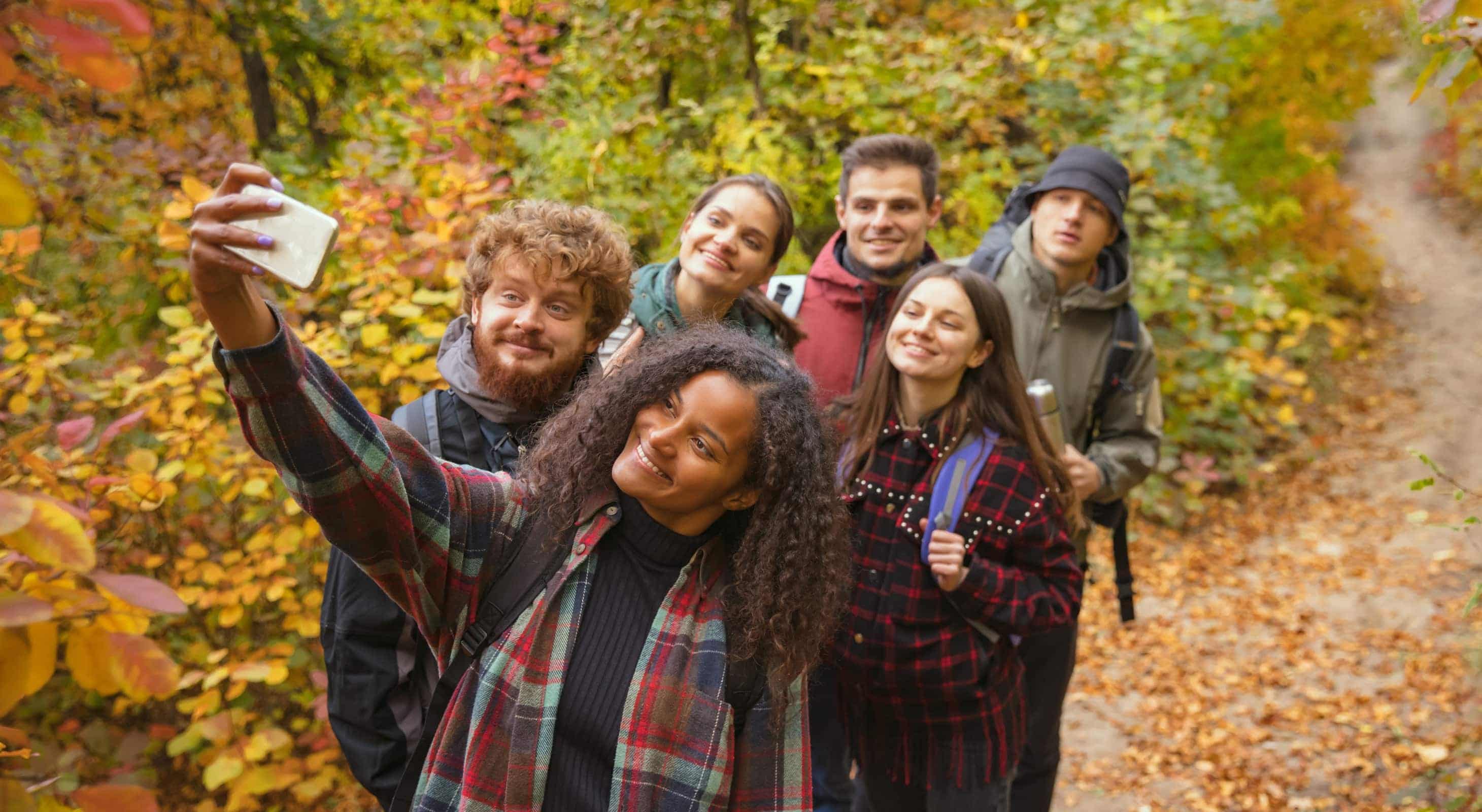 Group of young adults taking selfie while hiking in Vermont Fall Foliage