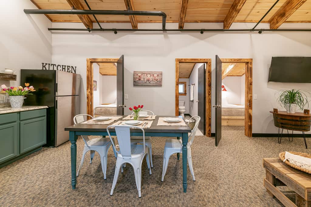 A family unit at our lodging in Vermont with a full kitchen, dining table, and two bedrooms.
