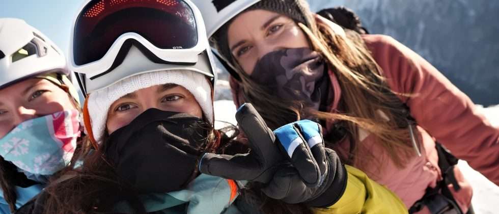 A group of women in ski gear taking a selfie on a mountain during a Vermont winter girls' getaway.