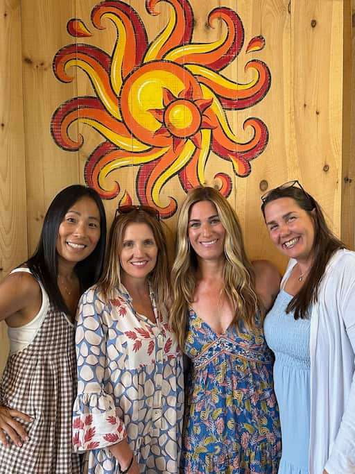A group of women next to a painting at Lawson's Finest Liquids in Waitsfield, VT, during a girls' getaway.