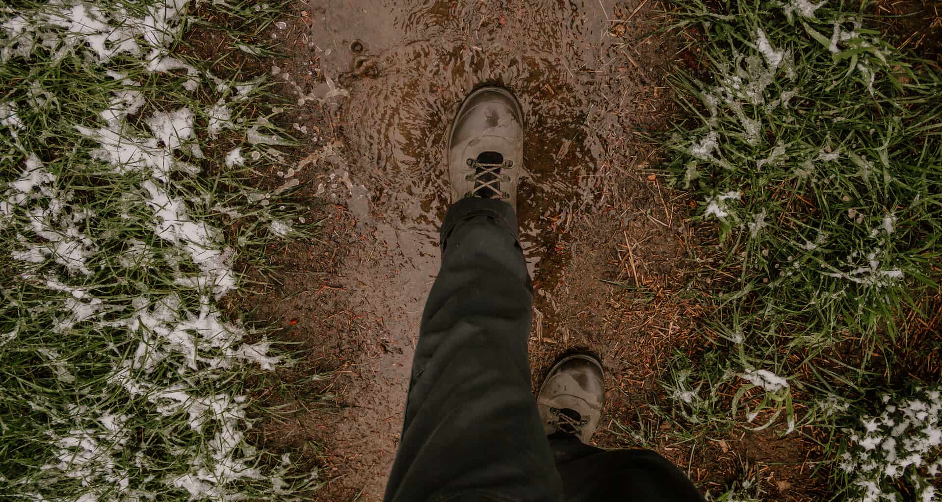 A person walking through a muddy path during mud season in Vermont