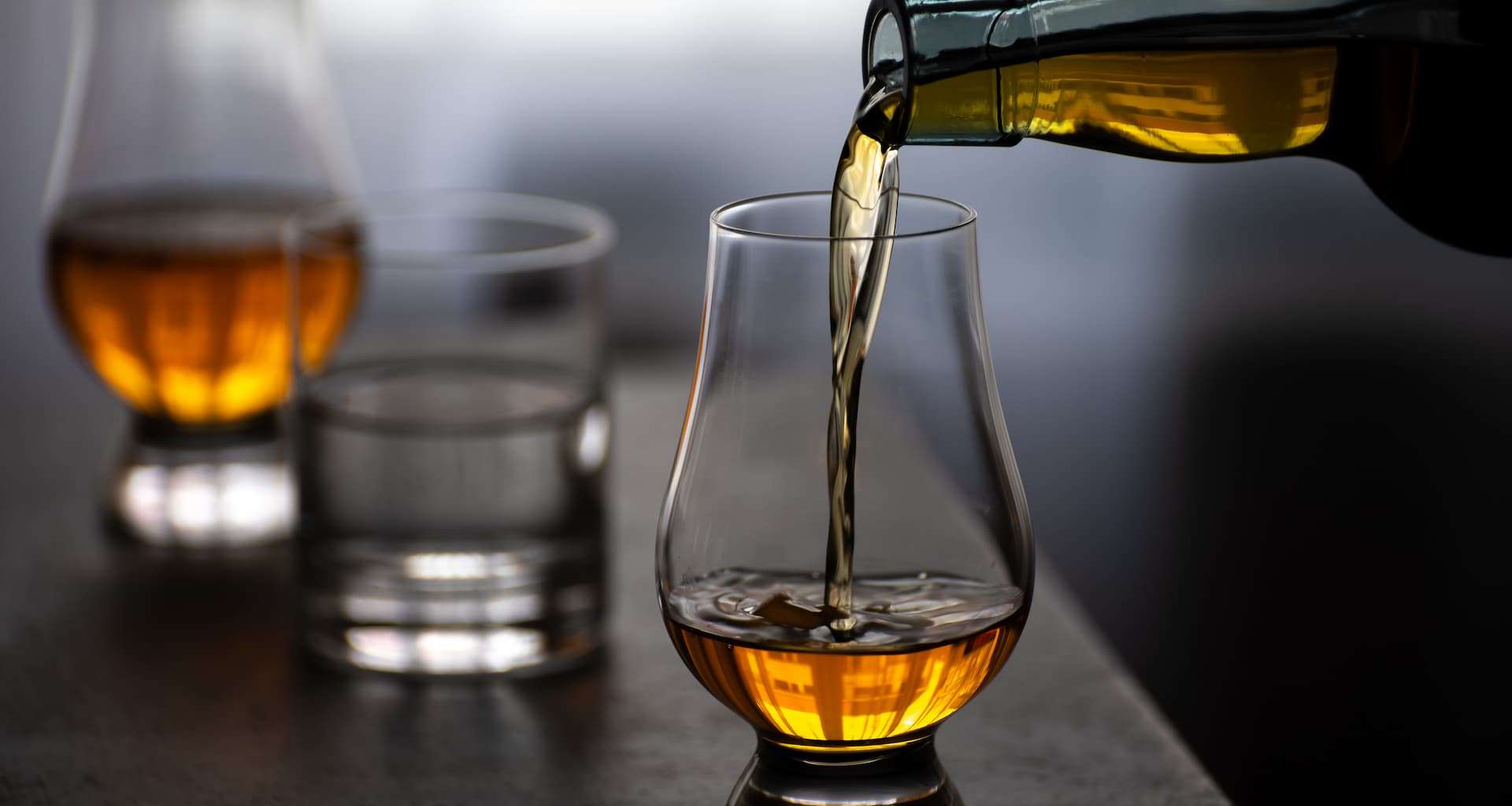 Someone pouring a glass of whiskey at a Vermont distillery